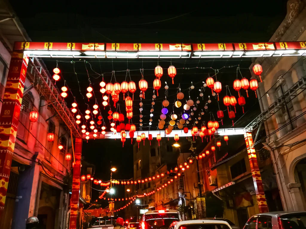 Red Chinese lanterns hanging above a city street at night