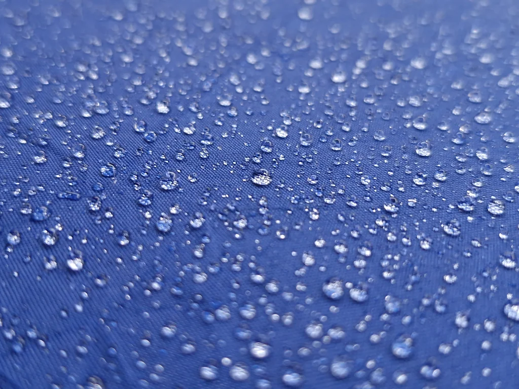 Raindrops on a blue umbrella during wet weather